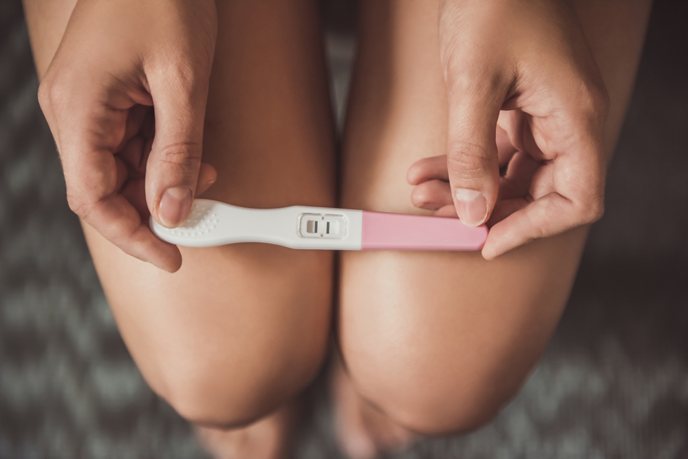 woman holding pregnancy test.