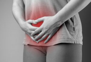 woman holding her stomach in pain.