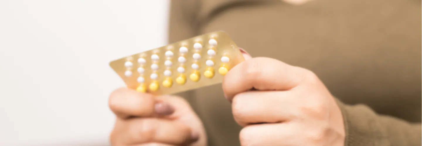 A person holds a blister pack of birth control pills.