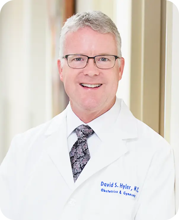 Dr. David S. Hyler, M.D., smiling in a white lab coat and glasses.