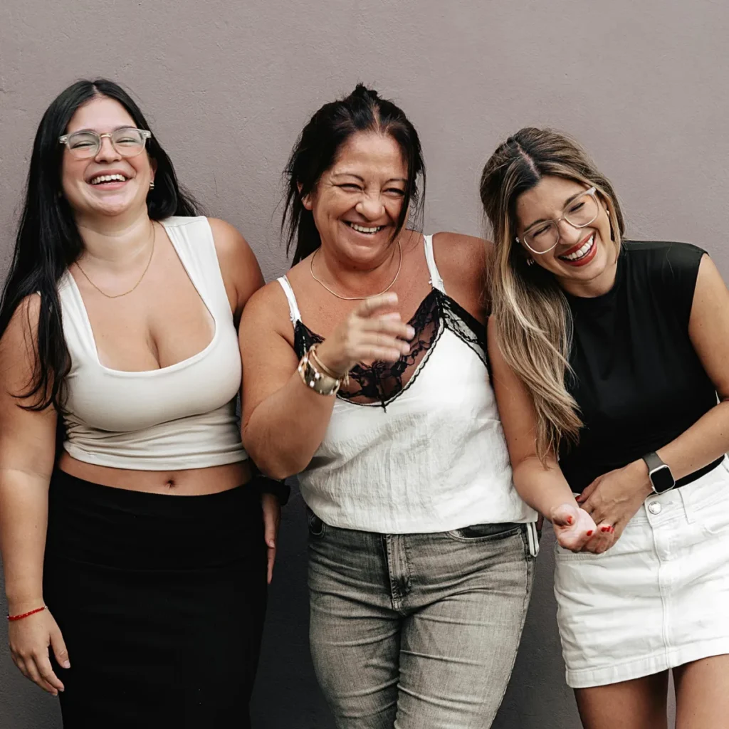 Three women of different generations smiling and laughing together.