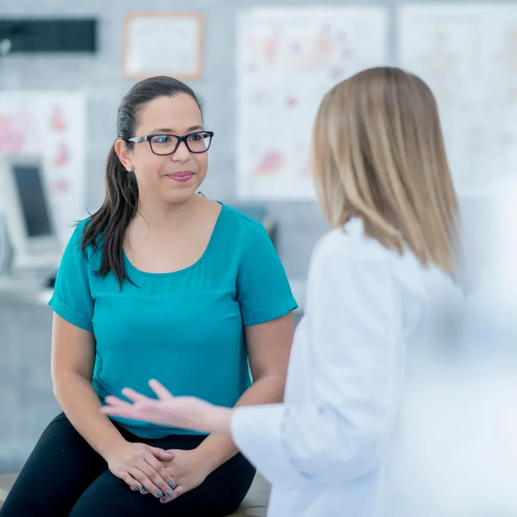A female patient listens attentively to a doctor during a medical consultation.