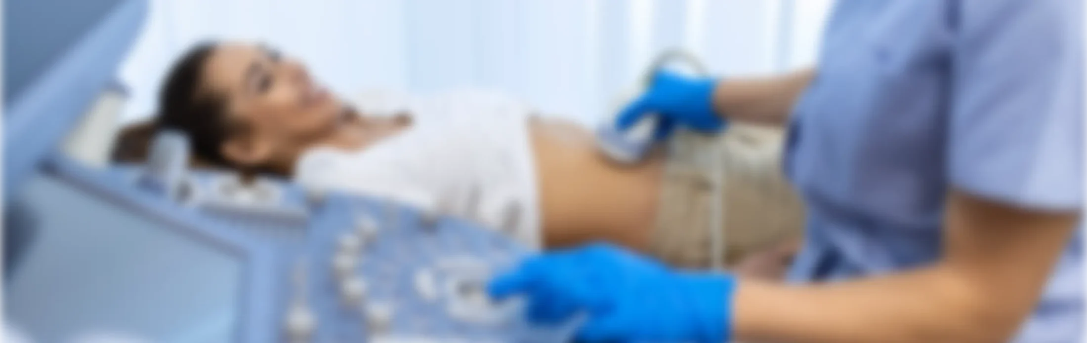 A healthcare professional performs an ultrasound on a patient's abdomen.