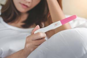 sad woman looking at pregnancy test result