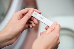 woman holding a pregnancy test