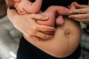 postpartum mom holding baby.