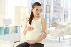 Young pregnant woman receiving vaccination