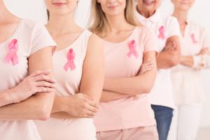 women standing together in pink with pink breast cancer ribbons